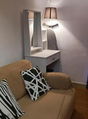 a room with a desk and a couch with a mirror at TriG Place at Grace Residence in Taguig City in Manila