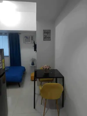 a dining room with a table and a yellow chair at Cozy Condo near US EmbassyErmita Manila/ Roxas blvd/ Dolomite beach in Manila
