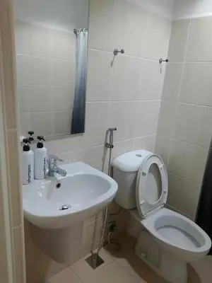 a bathroom with a white toilet and a sink at Cozy Condo near US EmbassyErmita Manila/ Roxas blvd/ Dolomite beach in Manila