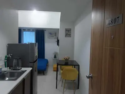 a kitchen with a sink and a table and a refrigerator at Cozy Condo near US EmbassyErmita Manila/ Roxas blvd/ Dolomite beach in Manila