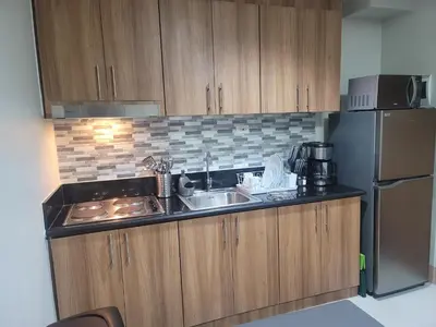 a small kitchen with a sink and a refrigerator at A&R Condo by the Bay in Manila