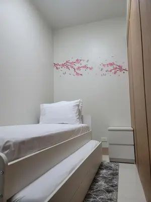 a bedroom with a bed with pink flowers on the wall at A&R Condo by the Bay in Manila