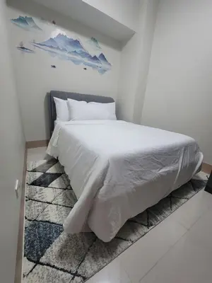 a bedroom with a large white bed with white sheets at A&R Condo by the Bay in Manila