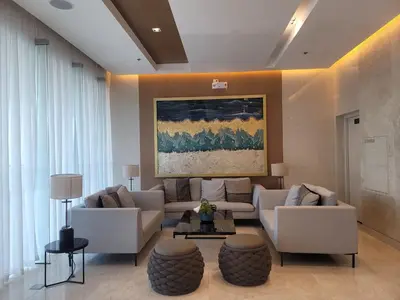 a living room with white furniture and a painting on the wall at A&R Condo by the Bay in Manila