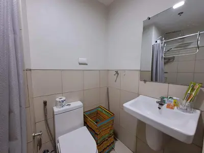 a bathroom with a white toilet and a sink at Elresa Elegant at Field Residences Condominium Hotel in Manila
