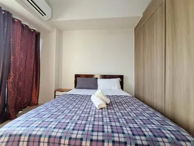 a bedroom with a large bed with a plaid blanket at Elresa Elegant at Field Residences Condominium Hotel in Manila