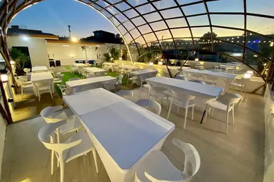 a restaurant with white tables and white chairs at Aurora Suites Pasay near Airport in Manila