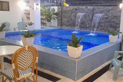 a swimming pool with a fountain in a house at Aurora Suites Pasay near Airport in Manila