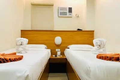 two beds in a hotel room with stuffed animals on them at Aurora Suites Pasay near Airport in Manila