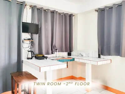 a room with a table and a tv and curtains at Cenco Suites Residences - Transient in Tanza Cavite in Tanza