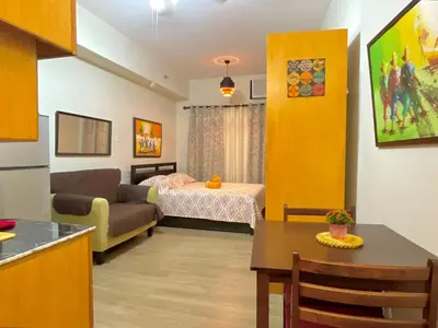 a small living room with a bed and a couch at Rafaella Sunset - Deluxe Room in Manila