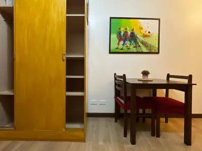 a dining room with a table and a picture on the wall at Rafaella Sunset - Deluxe Room in Manila