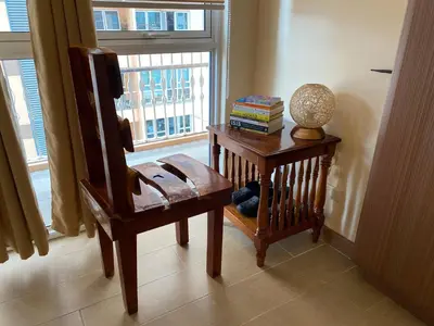 a room with a chair and a table and a window at Spacious condo in Venice Luxury Residences in Manila