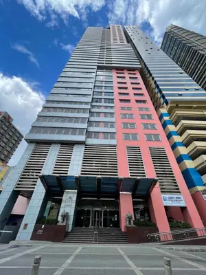 a tall building with a lot of windows at Pearl Of The Orient Tower, in front of US Embassy in Manila