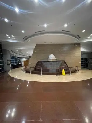a large lobby with a fountain in the middle of a building at Pearl Of The Orient Tower, in front of US Embassy in Manila