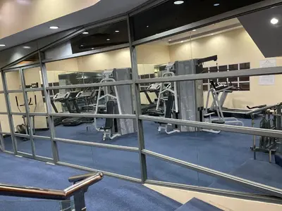 a gym with mirrors and some tread machines at Pearl Of The Orient Tower, in front of US Embassy in Manila