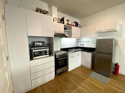 a kitchen with white cabinets and a stainless steel refrigerator at Modern Condo Apt in Flair Tower South, Mandaluyong in Manila