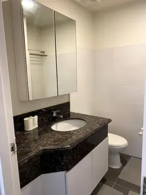 a bathroom with a sink and a toilet and a mirror at Modern Condo Apt in Flair Tower South, Mandaluyong in Manila