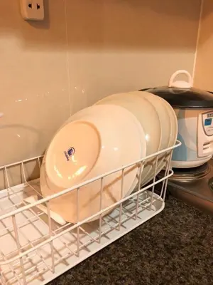 a dish rack with plates and pans in a kitchen at 101 Newport Boulevard-Favila Condotel Unit near Airport in Manila