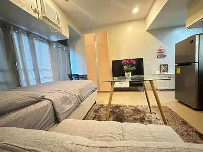 a bedroom with a bed and a table with flowers on it at EJ's Staycation 4th F with 200mbps Wi-Fi and NETFLIX in Manila