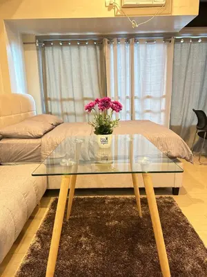 a glass coffee table with a vase of flowers on it at EJ's Staycation 4th F with 200mbps Wi-Fi and NETFLIX in Manila