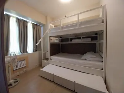 a bedroom with a bunk bed with white shelves at KENN PROPERTY in Manila