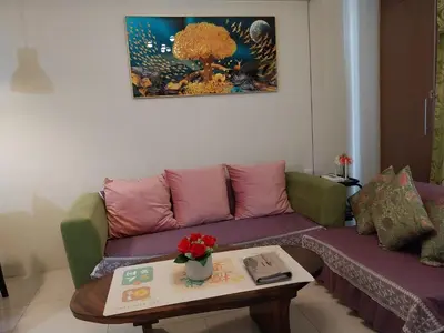 a living room with a purple couch and a table at KENN PROPERTY in Manila