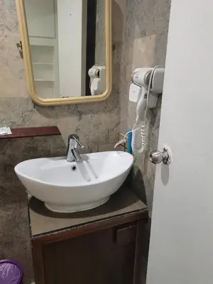 a bathroom with a white sink and a mirror at accommodation service in Manila