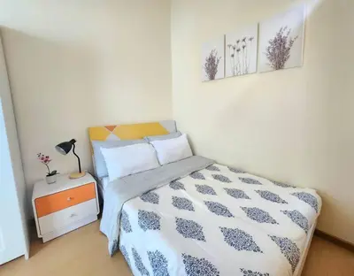 a small bedroom with a bed and a night stand at BGC Fresh & Cozy Studio near Burgos Circle with Fast Internet Connection in Manila