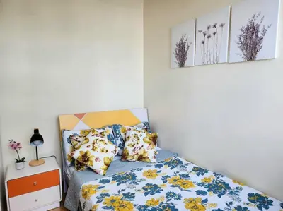 a bedroom with a bed with blue and yellow flowers at BGC Fresh & Cozy Studio near Burgos Circle with Fast Internet Connection in Manila