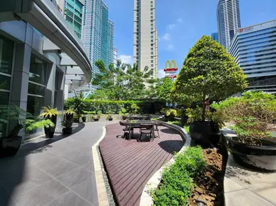 a park with tables and benches in a city at BGC Fresh & Cozy Studio near Burgos Circle with Fast Internet Connection in Manila