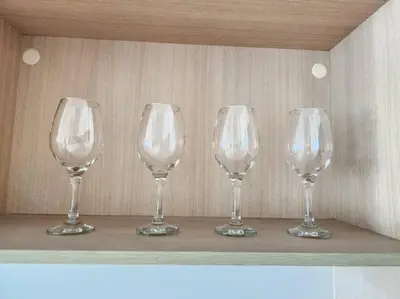 four empty wine glasses sitting on a shelf at BGC Fresh & Cozy Studio near Burgos Circle with Fast Internet Connection in Manila