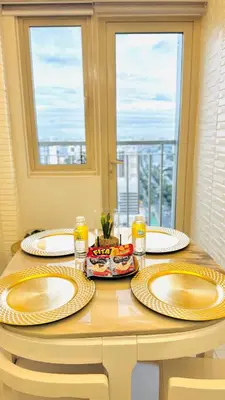 a table with three plates on top of it with a window at Coast Residence 4026 PENTHOUSE 1 Bedroom Condo with Wifi & Netflix in Manila