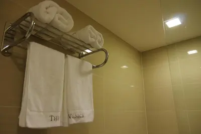 a bathroom with towels hanging on a towel rack at Luxe in Venice in Manila