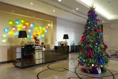 a christmas tree in a lobby with balloons at Luxe in Venice in Manila