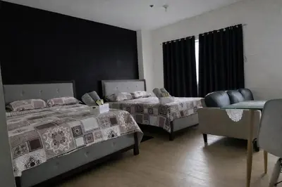 a bedroom with two beds and a chair and a window at J & F Homestay - Cavite, Philippines in Trece Martires