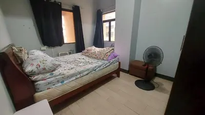 a bedroom with a bed and a window and a fan at 1 Br Near Naia T3/Resorts World in Manila