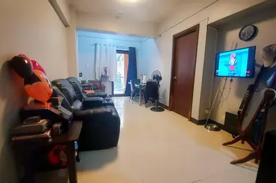 a living room with a couch and a television at 1 Br Near Naia T3/Resorts World in Manila