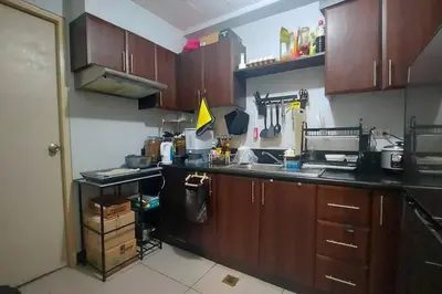 a kitchen with wooden cabinets and a counter top at 1 Br Near Naia T3/Resorts World in Manila