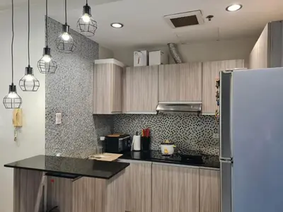 a kitchen with wooden cabinets and a refrigerator at Huge condo unit near Burgos Circle, St Lukes, Shangri-La - P Hamptons T1 in Manila