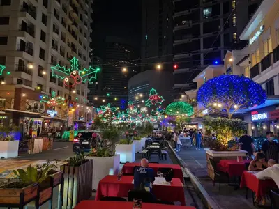 a city street at night with christmas lights at Huge condo unit near Burgos Circle, St Lukes, Shangri-La - P Hamptons T1 in Manila