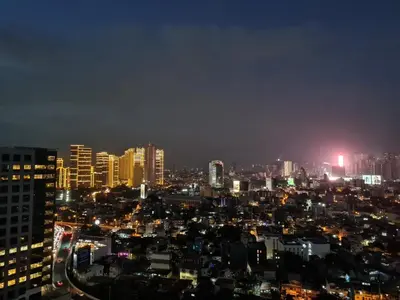 a view of a city at night with buildings at Huge condo unit near Burgos Circle, St Lukes, Shangri-La - P Hamptons T1 in Manila