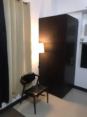 a chair and a lamp in a room at Casa Antonio at Stamford McKinley Hill Unli Wi-Fi Near Piazza in Manila