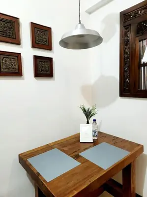 a wooden table against a white wall with a lamp at Casa Antonio at Stamford McKinley Hill Unli Wi-Fi Near Piazza in Manila