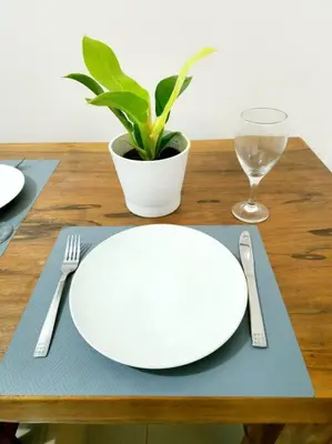 a table with a white plate and a fork and knife at Casa Antonio at Stamford McKinley Hill Unli Wi-Fi Near Piazza in Manila