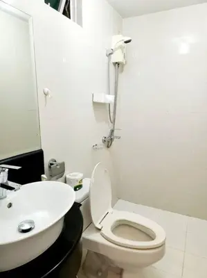 a white bathroom with a toilet and a sink at Casa Antonio at Stamford McKinley Hill Unli Wi-Fi Near Piazza in Manila