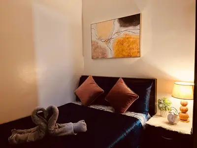 a living room with a black leather couch with pillows at Condominium at Spring Residences near Airport in Manila