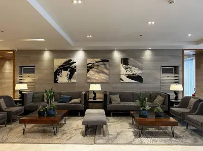 a living room with couches and tables and paintings at Hygge Suite @ Moa complex near Naia, Ccp , Dfa in Manila