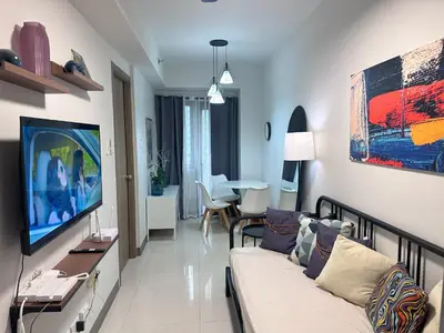 a living room with a couch and a tv at Hygge Suite @ Moa complex near Naia, Ccp , Dfa in Manila