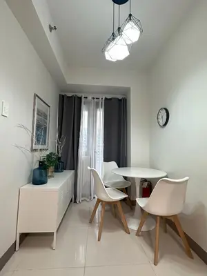 a white dining room with a table and chairs at Hygge Suite @ Moa complex near Naia, Ccp , Dfa in Manila